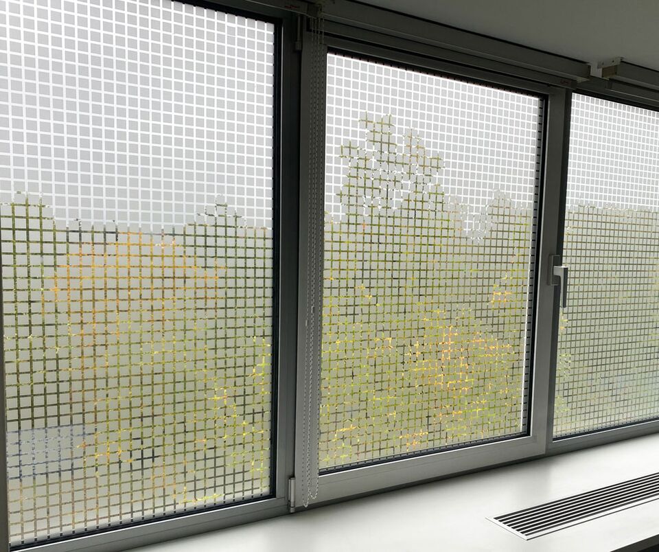 Glasscheibe mit einer Sichtschutzfolie in einem modernen Rastermuster.